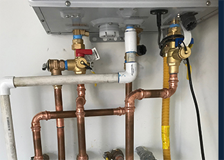 Copper and PVC pipes connected beneath a fixture