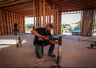 A JFC plumber working on plumbing in a home that is under construction